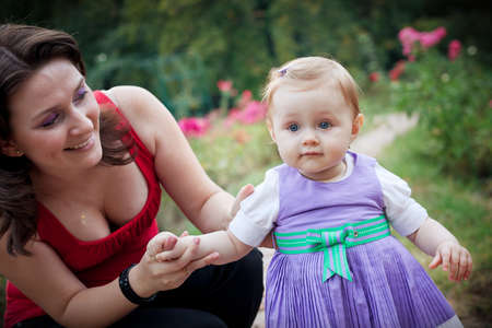 Learning to walk - mother helping her little daughterの写真素材