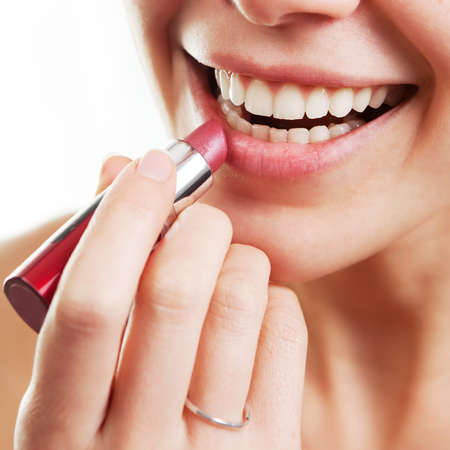 Lipstick and happy female lips over whiteの写真素材