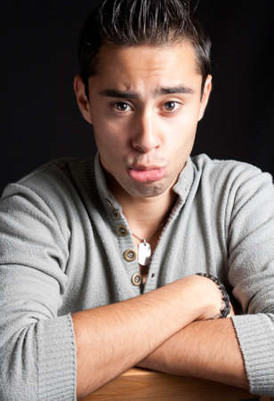Funny young man with fake sad expressionの写真素材