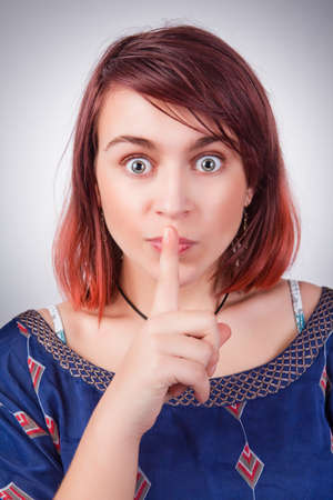 Silence - funny young woman with finger over lipsの写真素材