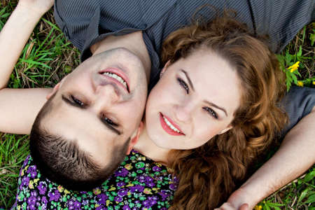 Cute couple portrait - happy young lovers on grassの写真素材