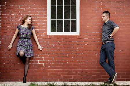 Happy young couple and house with brick wallの写真素材