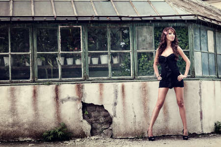 One sexy elegant woman posing in front of grungy wallの写真素材