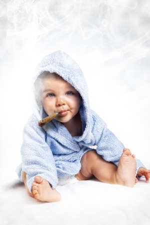 Smoking addiction concept - child puffing a cigar over whiteの写真素材