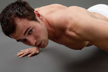 Fitness concept - sexy muscular man doing push-upsの写真素材