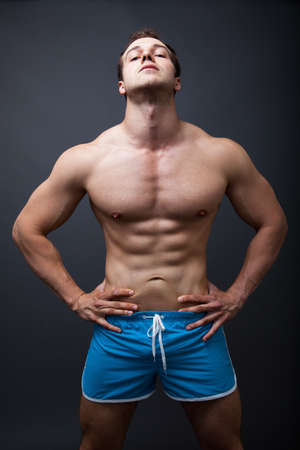Sexy man with muscular athletic body posing in studioの写真素材