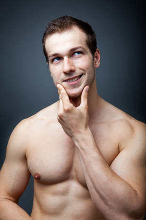 Muscles or brain concept - muscular man thinkingの写真素材