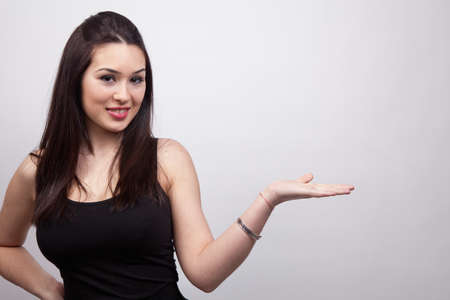 Cute friendly woman showing or holding somethingの写真素材