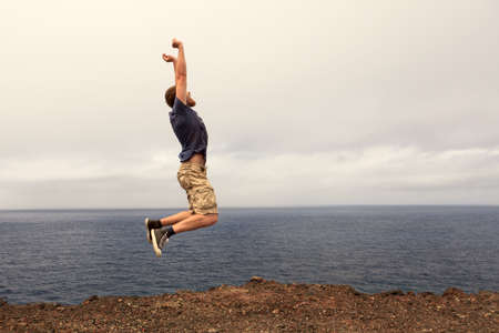 Success or win concept - joyful man jumping outdoorの写真素材
