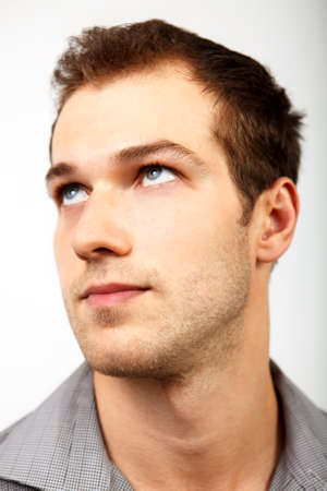 Face of serious man looking up over whiteの写真素材