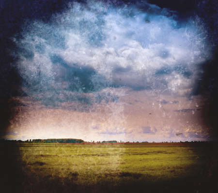 Vintage landscape - cloudy sky and green fieldの写真素材