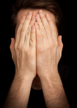 Depression concept  man covering face with handsの写真素材