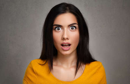 Surprise  face of amazed young womanの写真素材