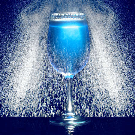 Glass of blue fresh liquid drink with water dropsの写真素材