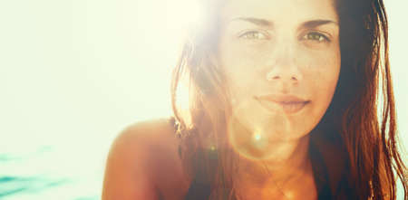 Face of young beautiful woman in summer sunの写真素材