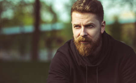 Handsome confident bearded young man outdoorの写真素材