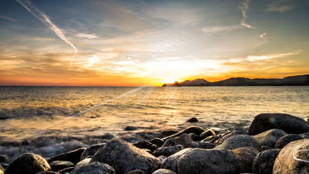 unfocused sunset with stones in the foregroundの写真素材