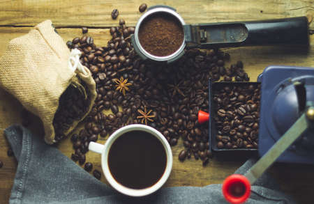 black coffee cup on old wood with coffee beans and old grinderの写真素材