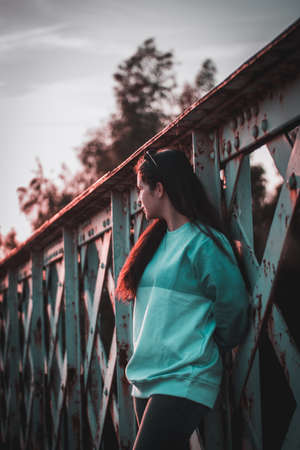 session on old iron bridge at sunset with bicycle and skateboardsの写真素材