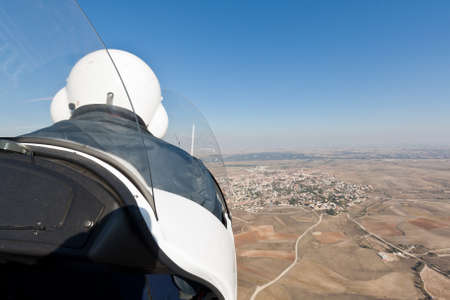 An autogyro is flying to a little villageの写真素材