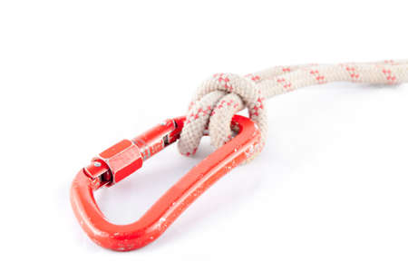 Old and used red carabiner with a white rope