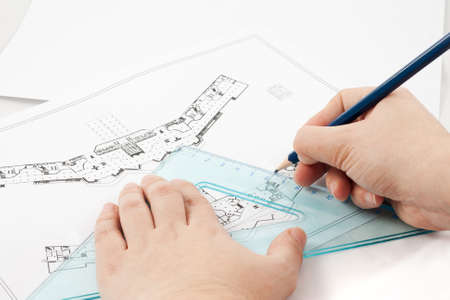 Design drawings and a hand drawing a project by pencil on paper
