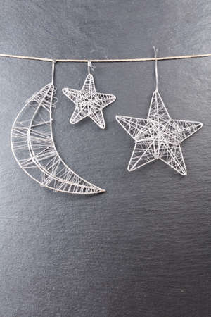 Christmas ornament  Moon and stars with a slate stone as backgroundの写真素材