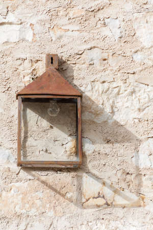 Old and rusty lantern with shadow on wallの写真素材