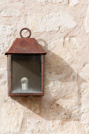 Old and rusty lantern with shadow on wallの写真素材
