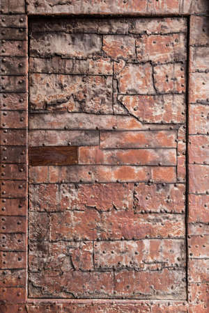 Rusty metal plate with a seam and rivets for backgroundの写真素材
