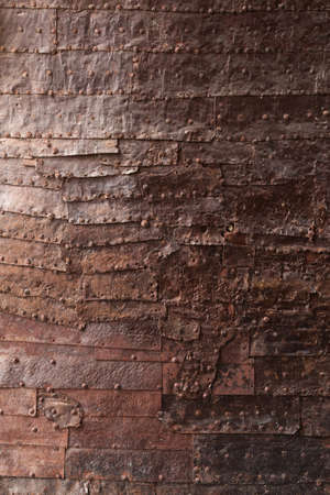 Rusty metal plate with a seam and rivets for backgroundの写真素材