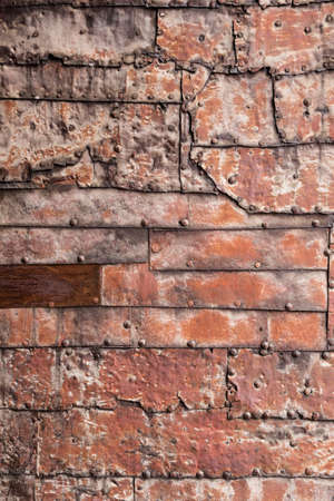 Rusty metal plate with a seam and rivets for backgroundの写真素材