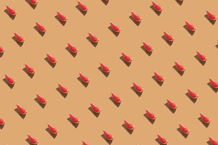 Creative pattern made of  fresh red grapefruit slices on the pastel orange background. Minimal summer fruit layout.の写真素材