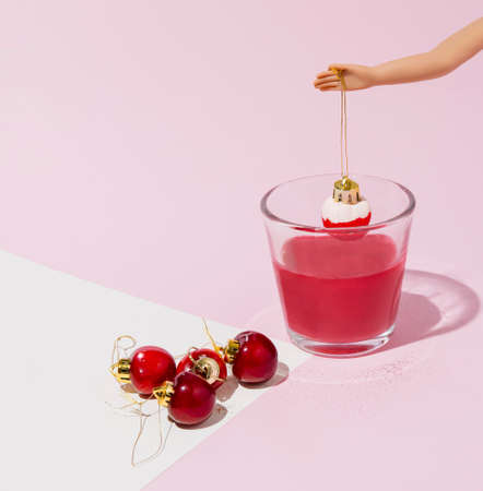 Creative layout made of cherries.Christmas bauble concept. Holiday pastel pink background.の写真素材