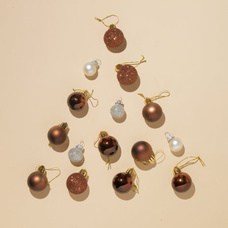 Nude and silver christmas baubles on the beige background. Christmas tree silhouette with shadows. Flat lay new year concept.の写真素材