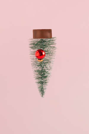 Falling christmas tree with a red bauble. Pink background. New Year composition. Winter holidays scene. Reindeer concept.の写真素材