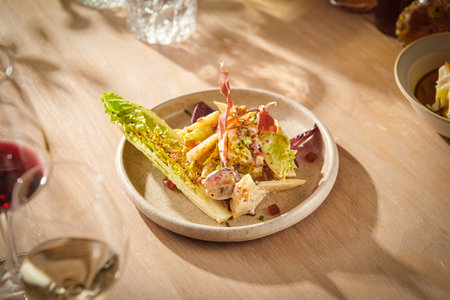 salad with meat and vegetables on a wooden table in a restaurantの写真素材