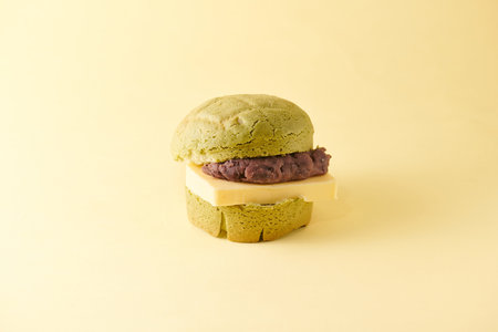 Green tea macaroon with chocolate on yellow background, close up