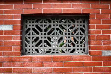 There is a beautiful window in the wall facing the street