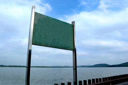 Along the park's lakeside, there are signs reminding people to be safeの写真素材