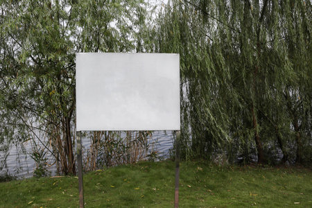 Along the park's lakeside, there are signs reminding people to be safeの写真素材