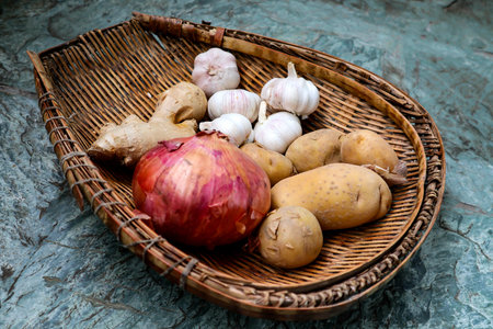It is a unique Chinese bamboo vessel containing garlic, Onions and potatoesの写真素材