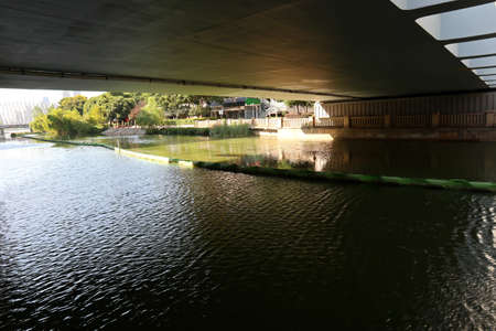 A view of a bridge over a river in a city park.の写真素材