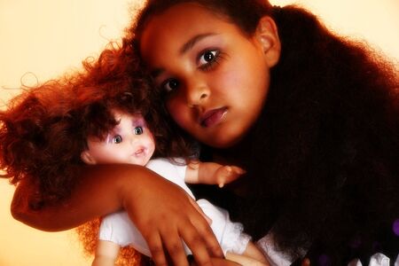 Beautiful 10 year old African Amercain girl with  doll in goth theme.の写真素材