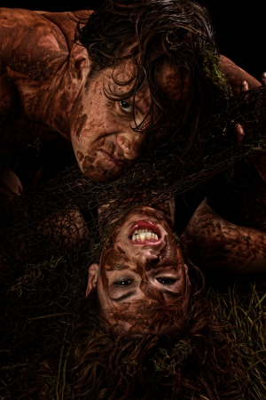 Fantasy character portrait of couple in mud over black.の写真素材