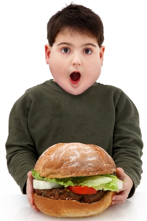 Hungry obese child with giant hamberger over white.の写真素材