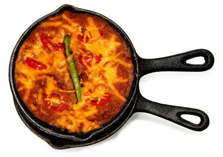 Skillet Refried Beans with Hot Peppers, Cherry Tomatos and Cheddar Cheese over white の写真素材