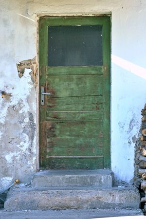 Old green door by the cottageの写真素材