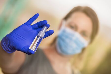 STOP Coronavirus, blonde woman with protective medical mask and surgical gloves shows antiseptic...