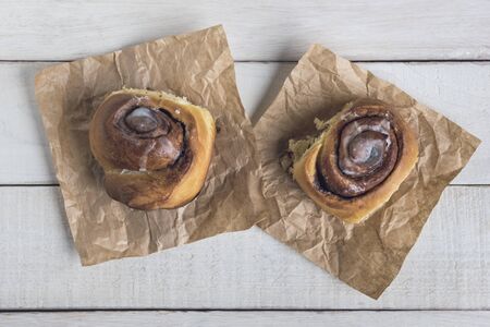 Two cinnamon rolls ready to eat over a white rustic wooden table. Top viewの写真素材
